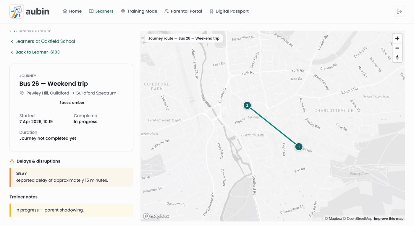 A learner's journey record in Aubin Travel Training, showing a bus trip in progress, an amber stress rating, a 15-minute delay alert, trainer notes and the route on a map.